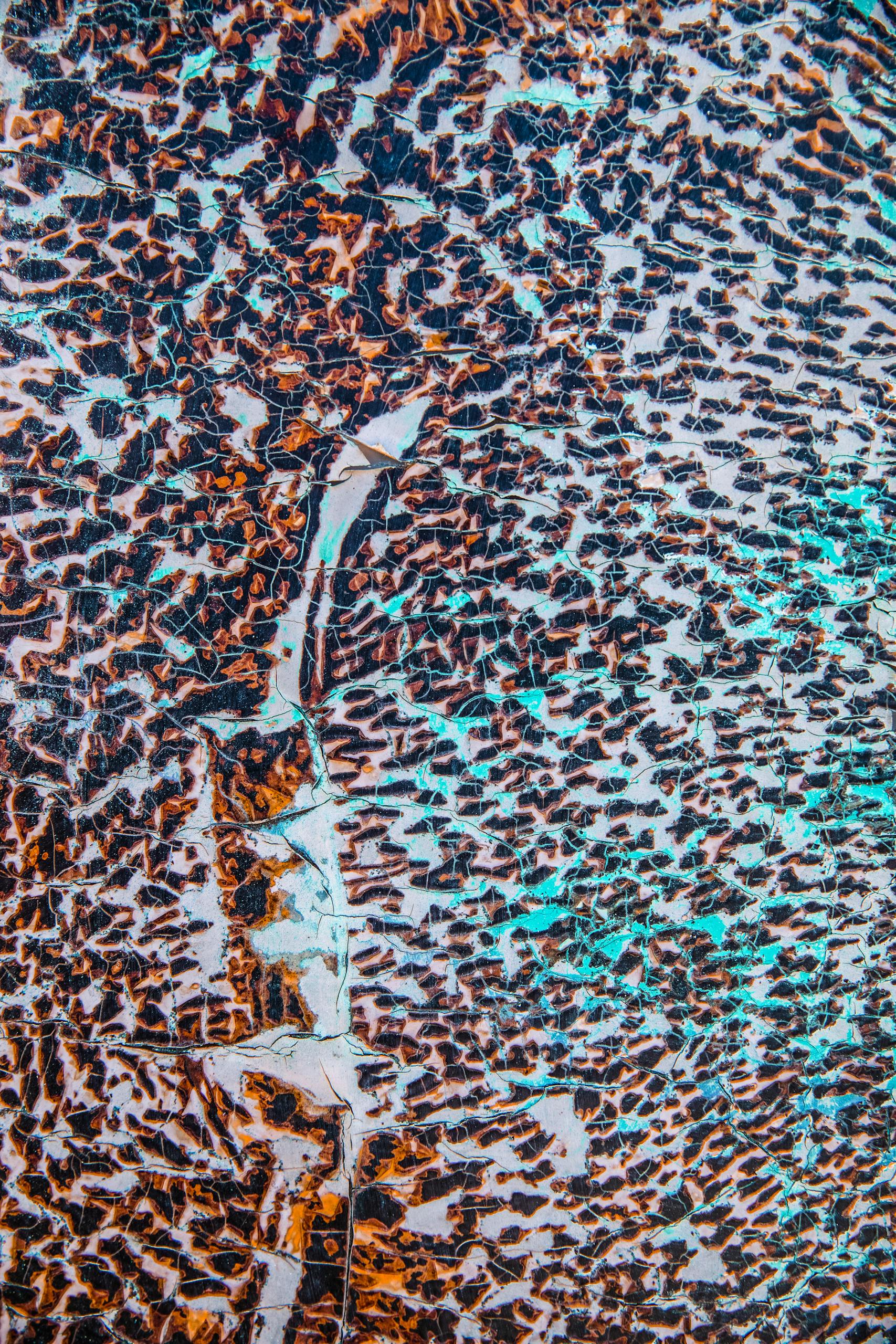 Close-up of colorful cracked earth texture with abstract marbling patterns.